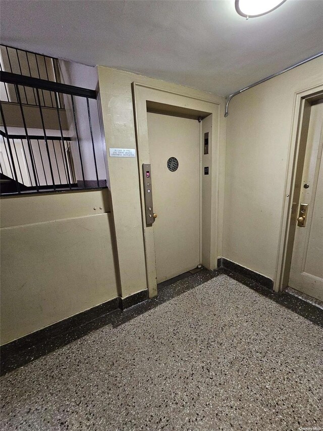 interior space featuring a textured ceiling and elevator