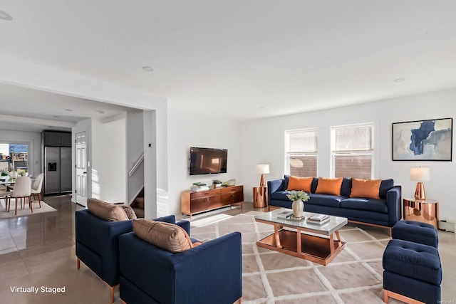 living room featuring a healthy amount of sunlight and a baseboard heating unit