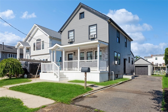 view of front of house featuring a porch, a garage, an outdoor structure, and a front yard