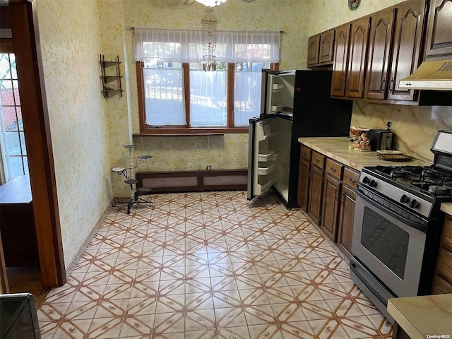 kitchen with dark brown cabinetry, ventilation hood, and stainless steel gas range