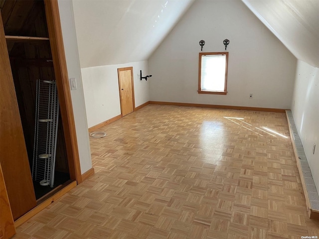 bonus room featuring light parquet floors and vaulted ceiling