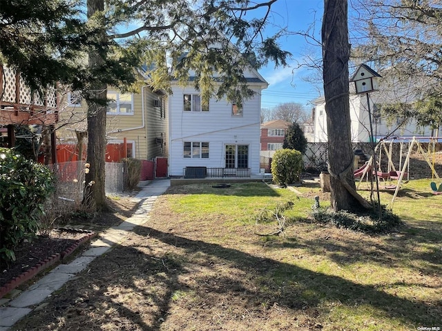 back of house featuring central AC unit and a lawn