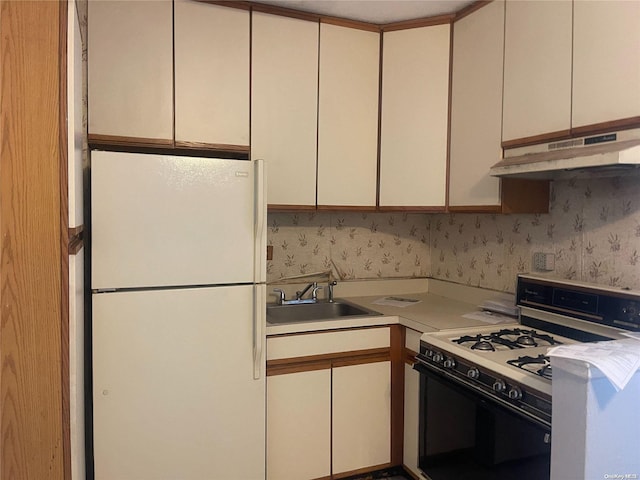 kitchen with white cabinetry, sink, and white appliances