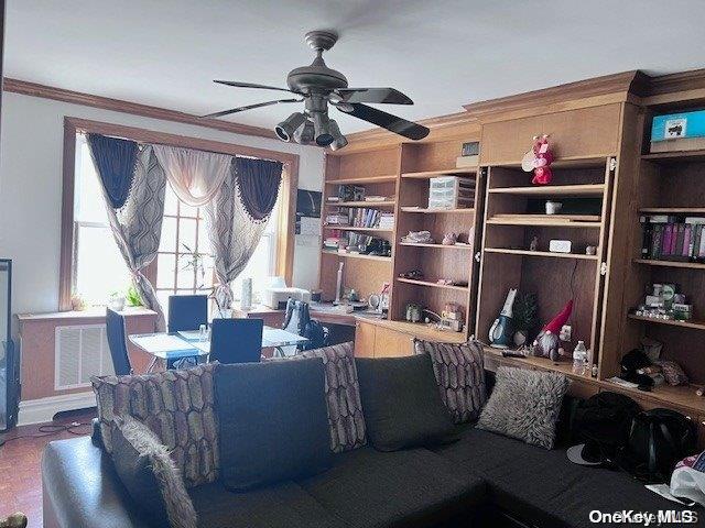 living room featuring ceiling fan and crown molding