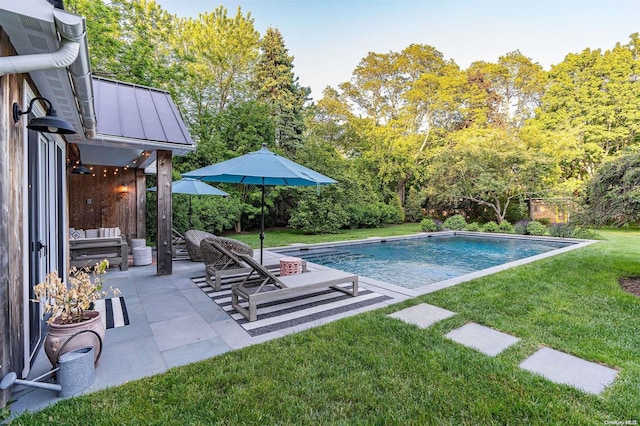 view of swimming pool featuring a patio area and a yard