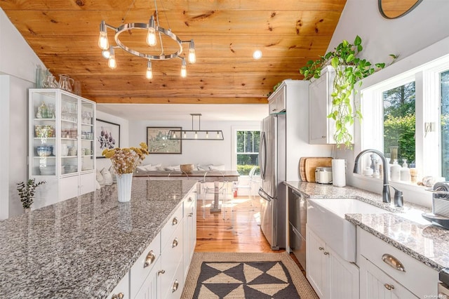 kitchen with light stone countertops, white cabinets, wood ceiling, and light wood-type flooring