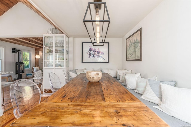 dining room with wood-type flooring and a wood stove