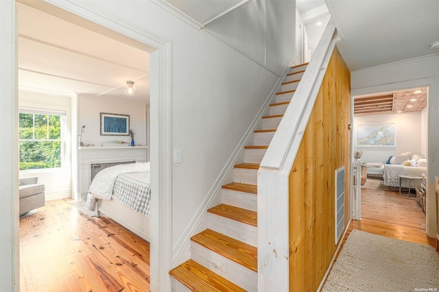 stairway with crown molding and hardwood / wood-style flooring