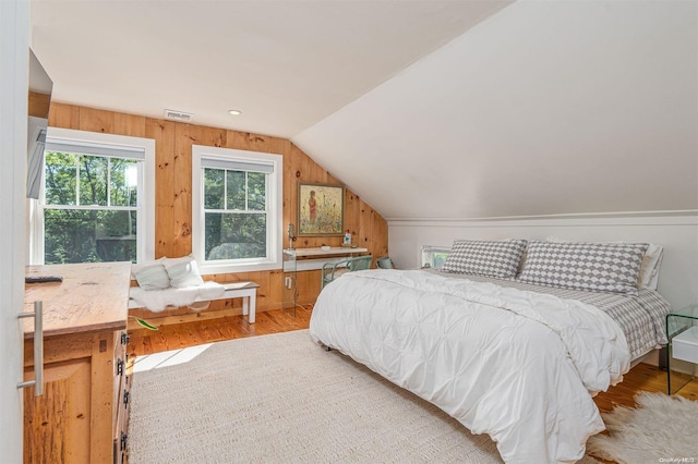 bedroom with hardwood / wood-style flooring and lofted ceiling