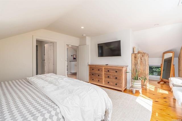 bedroom with hardwood / wood-style floors and lofted ceiling