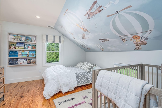 bedroom with hardwood / wood-style flooring and vaulted ceiling