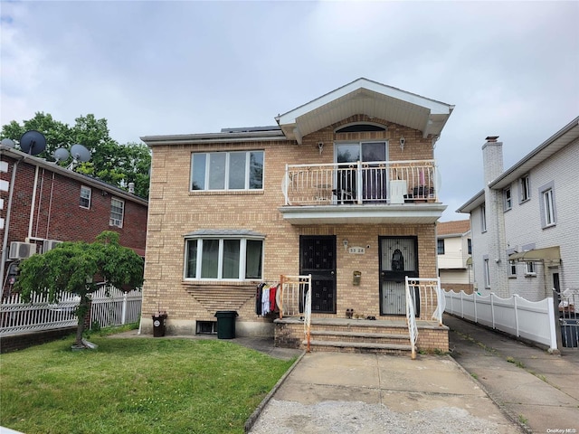 view of front facade featuring cooling unit, a balcony, and a front lawn