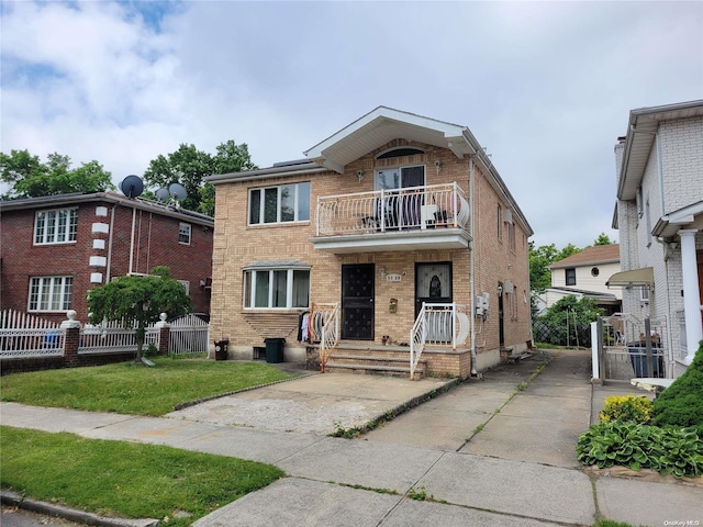 view of front of house featuring a balcony and a front yard