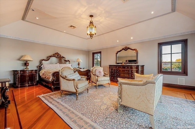 bedroom with wood-type flooring and a tray ceiling