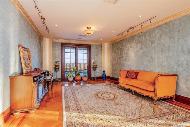 sitting room with crown molding, light parquet floors, and rail lighting