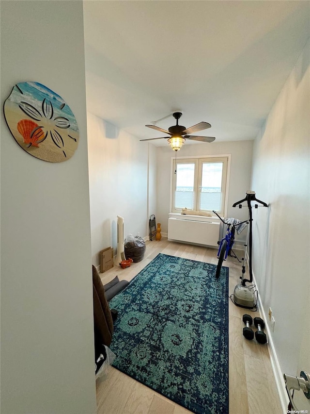 workout area with light wood-type flooring and ceiling fan