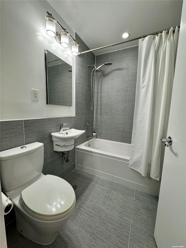 full bathroom with tile patterned floors, shower / bath combo, toilet, and tile walls