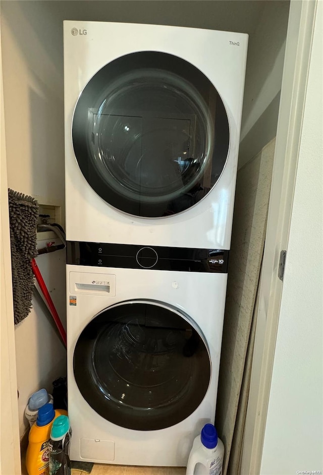 clothes washing area with stacked washer / dryer