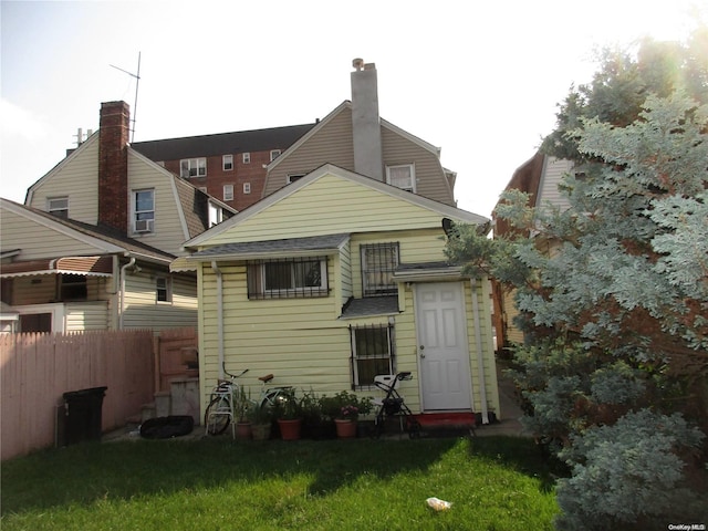 rear view of property featuring a lawn