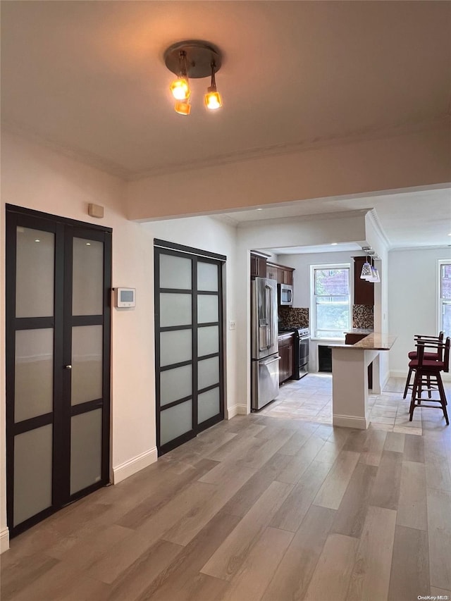 interior space featuring crown molding and light hardwood / wood-style floors