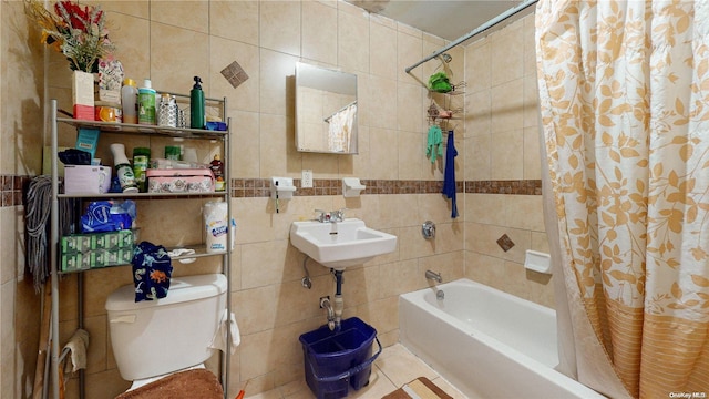 full bathroom featuring sink, tile patterned flooring, toilet, tile walls, and shower / tub combo with curtain