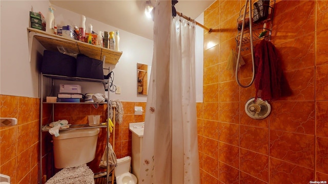 bathroom with curtained shower, tile walls, and toilet