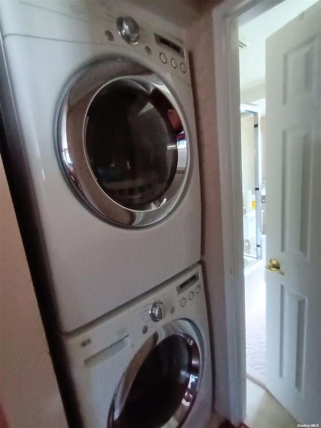 washroom featuring stacked washer / drying machine