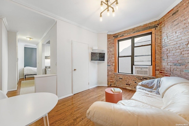 living room with cooling unit, wood-type flooring, ornamental molding, and brick wall