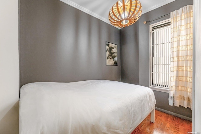 bedroom featuring wood-type flooring and ornamental molding