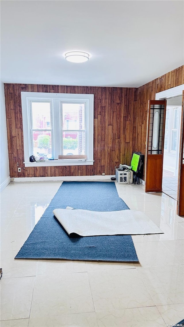 interior space featuring wood walls and light tile patterned floors