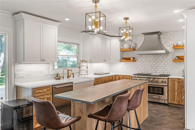 kitchen with white cabinets, appliances with stainless steel finishes, decorative backsplash, and wall chimney exhaust hood