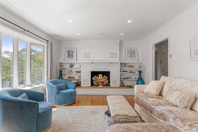 living room featuring hardwood / wood-style floors, ornamental molding, and a brick fireplace