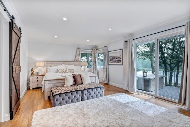 bedroom with a barn door, access to exterior, crown molding, and light wood-type flooring