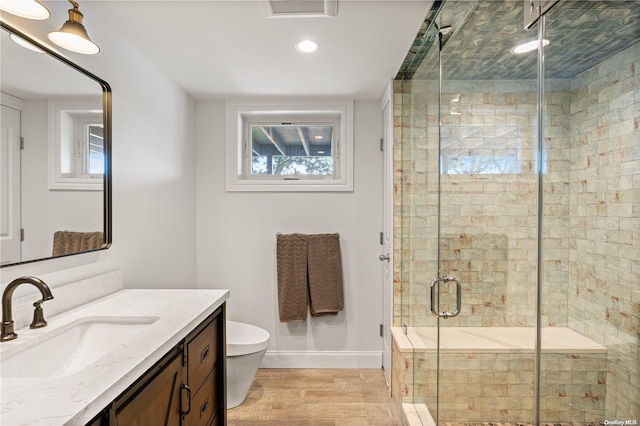 bathroom featuring walk in shower, toilet, vanity, and hardwood / wood-style flooring