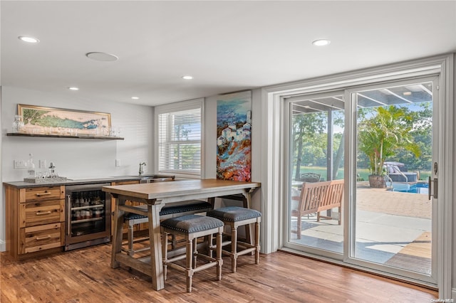 bar featuring hardwood / wood-style floors, wine cooler, and sink