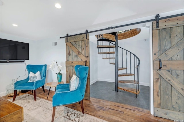 sitting room featuring a barn door and wood-type flooring