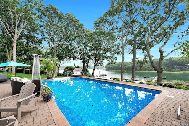 view of swimming pool with a water view, a patio, and a boat dock