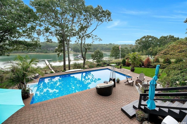 view of swimming pool with a patio, a water view, and a diving board