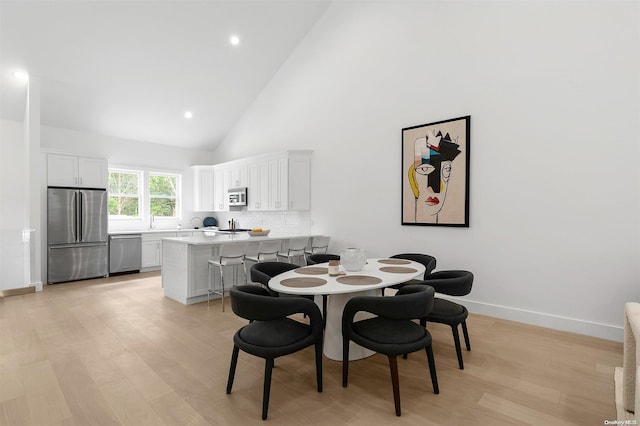 21 Montauk Hwy Unit 5, Westhampton, NY 11977 - dining room with light wood finished floors, high vaulted ceiling, baseboards, and recessed lighting