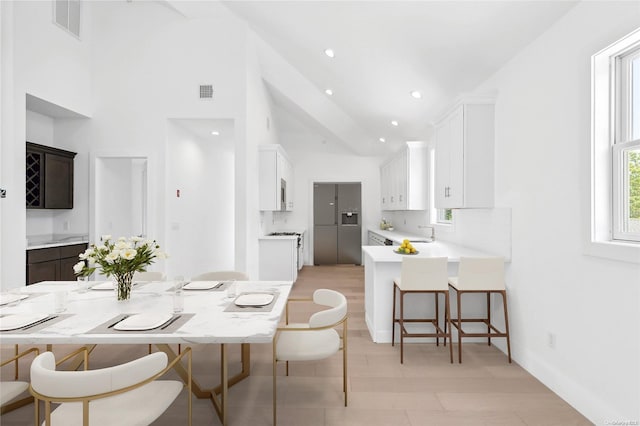 21 Montauk Hwy Unit 9, Westhampton, NY 11977 - dining area with high vaulted ceiling, baseboards, and recessed lighting