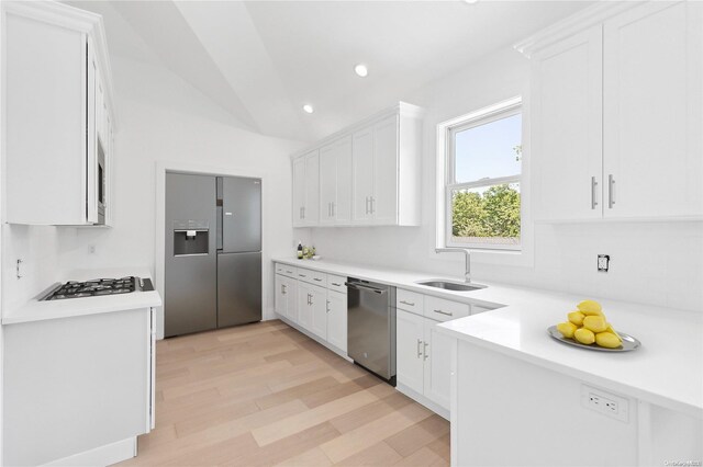 21 Montauk Hwy Unit 9, Westhampton, NY 11977 - kitchen featuring stainless steel appliances, a sink, decorative backsplash, white cabinets, and vaulted ceiling