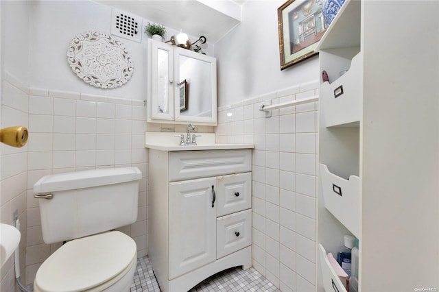 99-40 63rd Rd Unit 9Z, Rego Park, NY 11374 - bathroom with tile walls, tile patterned floors, vanity, toilet, and wainscoting