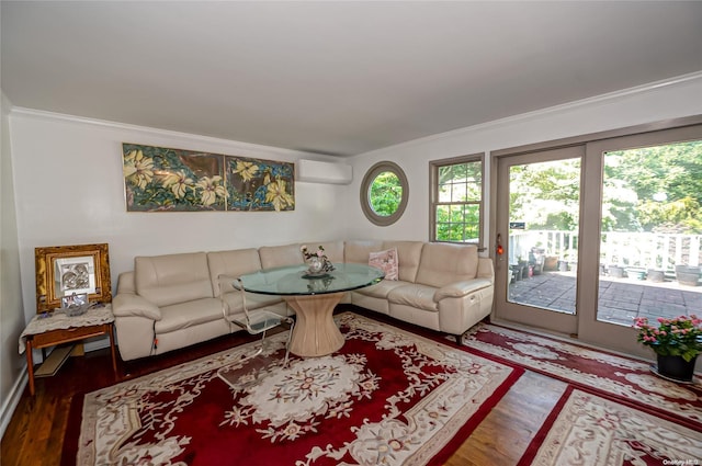 living room featuring hardwood / wood-style flooring, an AC wall unit, and crown molding