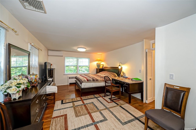 bedroom featuring radiator, dark wood-type flooring, and a wall unit AC