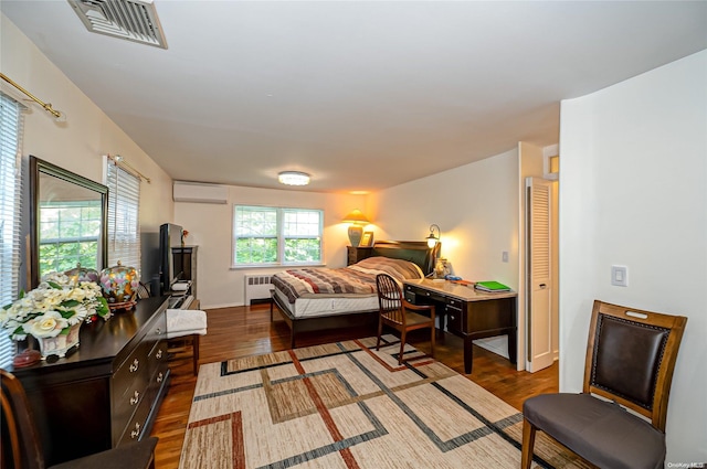 90 E Broadway, Roslyn, NY 11576 - bedroom featuring a wall unit AC, radiator heating unit, and wood finished floors