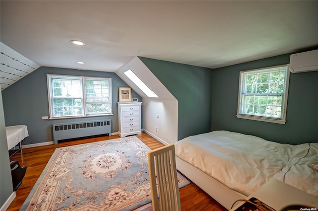 bedroom with hardwood / wood-style floors, lofted ceiling, radiator, and multiple windows