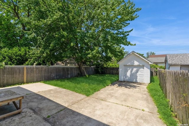 view of yard with a garage and an outbuilding