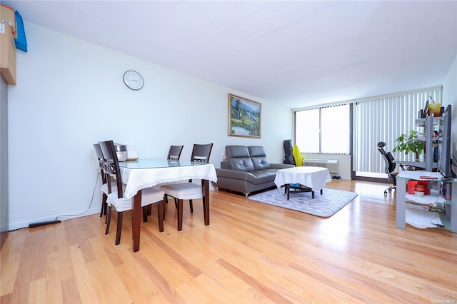 dining area with expansive windows and light wood-type flooring