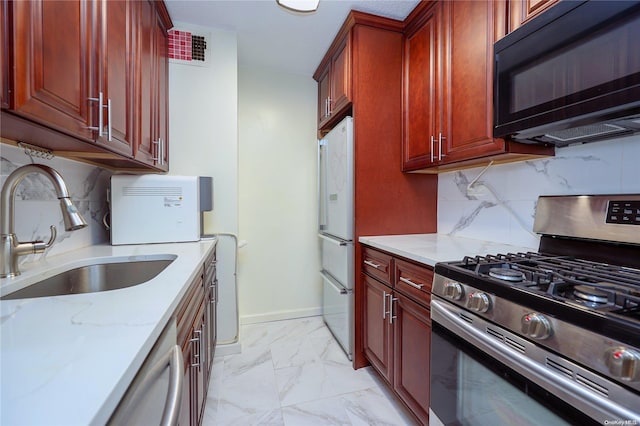 kitchen featuring decorative backsplash, light stone counters, white appliances, and sink