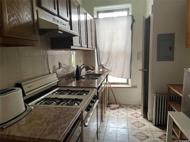 kitchen with gas range, dark brown cabinets, sink, radiator heating unit, and electric panel